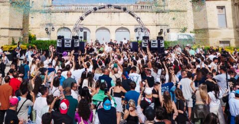 L'image montre le Chateau de Marsillargues, avec une scène où un DJ performe et des personnes dansent.