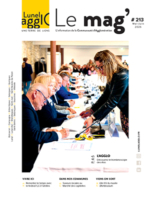 Photo prise lors d'un conseil communautaire avec le président signant un document qu'un agent lui tend. En arrière-plan se trouvent des conseillers communautaires puis des personnes venues assister à la séance. La photo illustre la couverture du mg' Lunel Agglo n° 213 de mai et juin 2026.